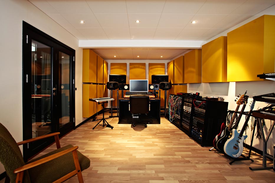 Music studio control room with monitors, guitars and outboard gear